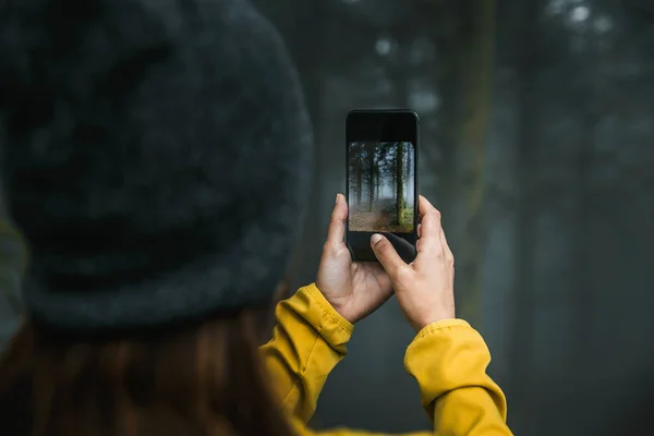 女旅行者拿着手机在森林里拍照 — 图库照片
