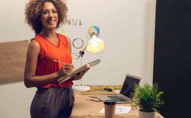 Atölyesinde çalışan genç bir moda tasarımcısı.