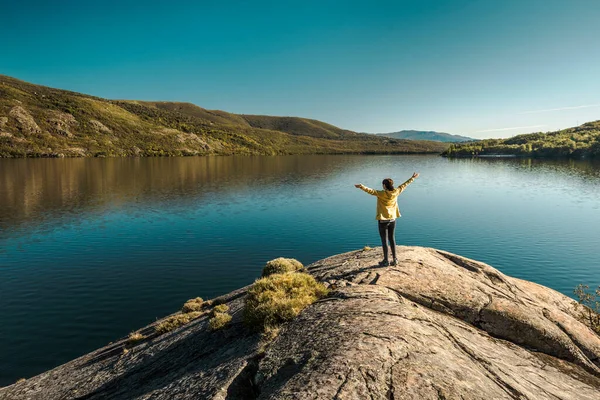 腕を上げて美しい湖の近くでハイキングする女性のショット — ストック写真