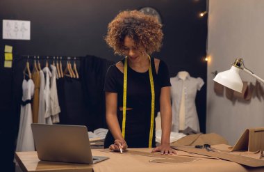 Atölyesinde çalışan genç bir moda tasarımcısı.