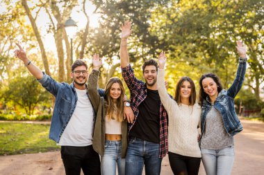 Dostlar kucaklaşır, kollar havada.