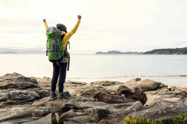 バックパックと腕を持つ女性が海岸の美しい朝の景色を楽しんで育ちました — ストック写真