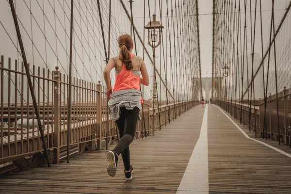 ブルックリン橋でジョギングをしている女性 — ストック写真