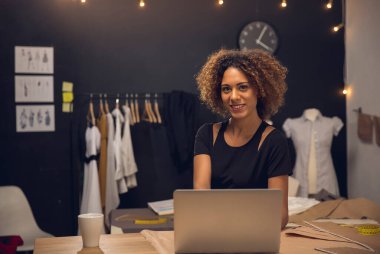 Atölyesinde çalışan genç bir moda tasarımcısı.