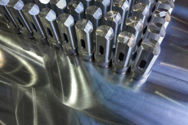 CNC tornalama ve frezeleme işleminden sonra seçici odaklama ile düz öğütülmüş yüzeyde parlak metal parçaların toplu işlemi.
