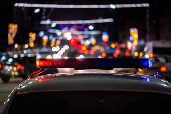 Поліцейські автомобільні вогні вночі в місті з вибірковим фокусом і боке — стокове фото