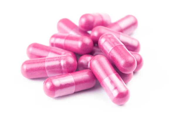 Pile of pink organic capsules isolated on white background closeup with selective focus — Stock Photo, Image