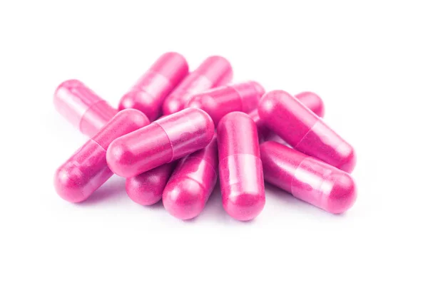 Pile of pink organic capsules isolated on white background closeup with selective focus — Stock Photo, Image