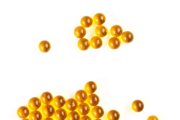 Orange spherical ball capsules of fish oil selective focus isolated on white background — Stock Photo, Image