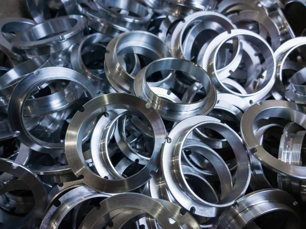 A batch of machined shiny metal parts with selective focus — Stock Photo, Image