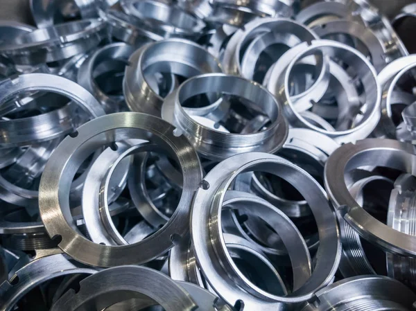 A batch of machined shiny metal parts with selective focus — Stock Photo, Image