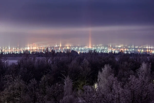 Paisagem urbana noite de inverno com pilares de luz fenômeno atmosférico — Fotografia de Stock