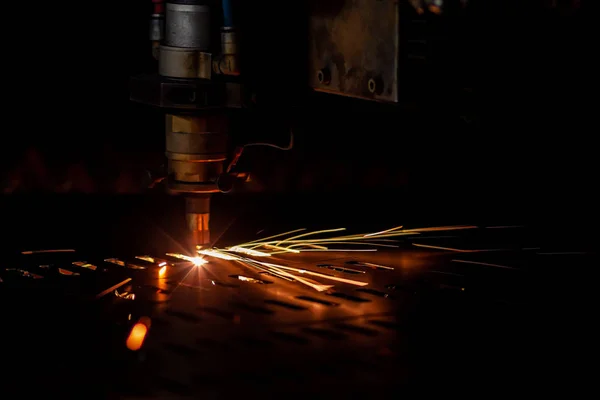 laser cutting process dark closeup with selective focus and sparks