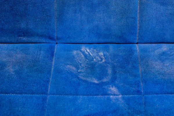 dusty blue sofa surface with palm prints closeup with selective focus