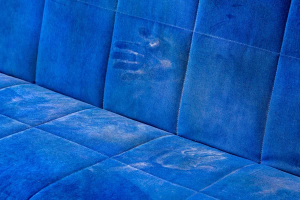 dusty blue sofa surface with palm prints closeup with selective focus