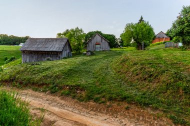 yaz akşamı biçilmiş çim ile bahçesinde eski ahşap ahırlar