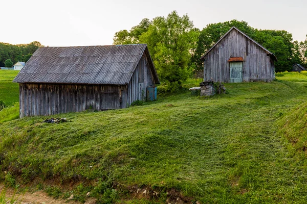 Yaz akşamı biçilmiş çim ile bahçesinde eski ahşap ahırlar — Stok fotoğraf