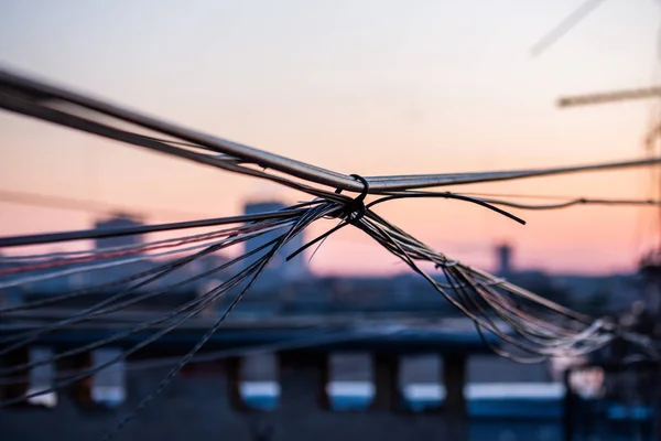 A wisp of wires on evening city roof with selective focus — Stock Photo, Image