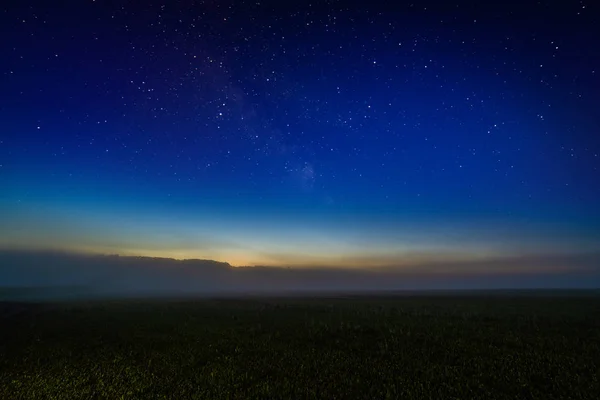 Туманное ночное поле со звёздным ночным небом и горизонтальным градиентом — стоковое фото