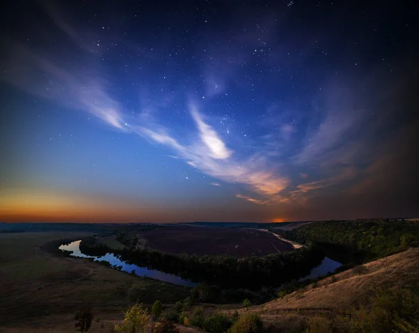 Летний пейзаж на берегу реки в звездную ночь с фиолетовыми облаками — стоковое фото