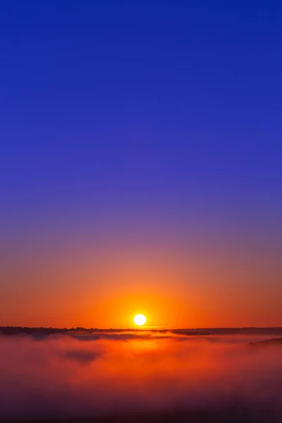 Золотисто-голубой летний восход солнца над туманом без облаков в минималистской композиции — стоковое фото