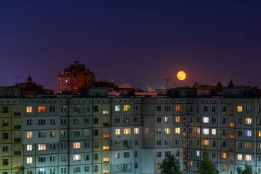 Rusya'da dolunay gecesinde toplu apartmanların pencereleri, çatıları ve cephesi.