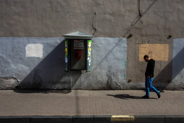 SAINT-PETERSBURG, RUSIA - JUNIO, 13 2014: Hombre adulto con auriculares caminando de lado cerca de la pared pintada con cabina . — Foto de Stock