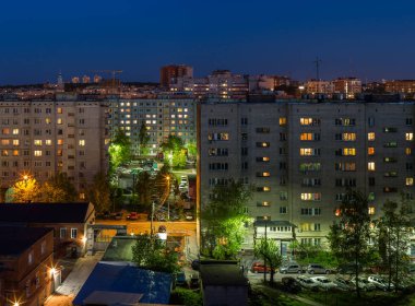 Yaz gecesi Rusya'da toplu bir apartmanın pencereleri, çatıları ve cephesi.