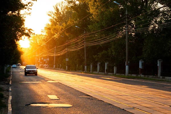 TULA, RUSSIA - JUNE 6, 2013: Car on city street under golden sun backlight. Air glowing bright. — Stock Photo, Image