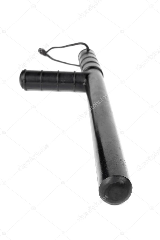 Black classic rubber police tonfa baton isolated on white background with selective focus and wide angle.