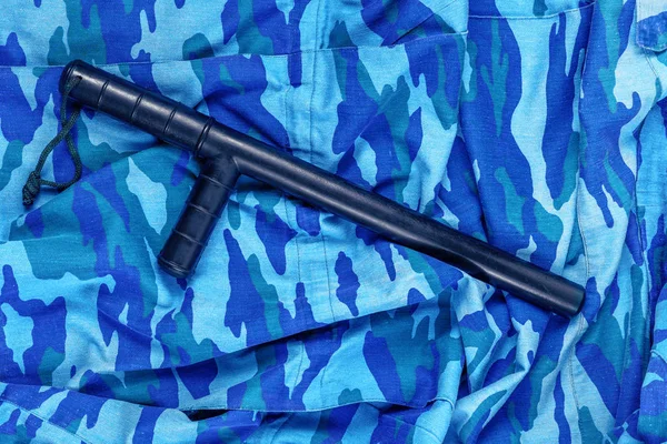 black rubber baton on blue urban russian riot police camouflage flat lay