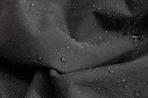 Темно-сіра водонепроникна гідрофобна тканина крупним планом з краплями дощу вибірковий фон — стокове фото