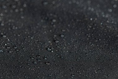 yağmur damlaları seçici odak arka plan ile koyu gri su geçirmez hidrofobik düz bez closeup