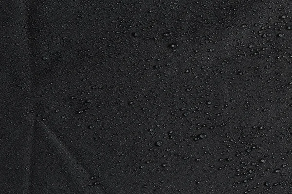 Tela plana hidrófoba impermeable gris oscuro primer plano con fondo de gotas de lluvia —  Fotos de Stock