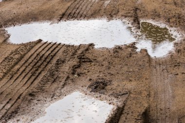 seçici odak ve bulanıklık ile yol kenarında kir telefoto closeup çekim su birikintileri