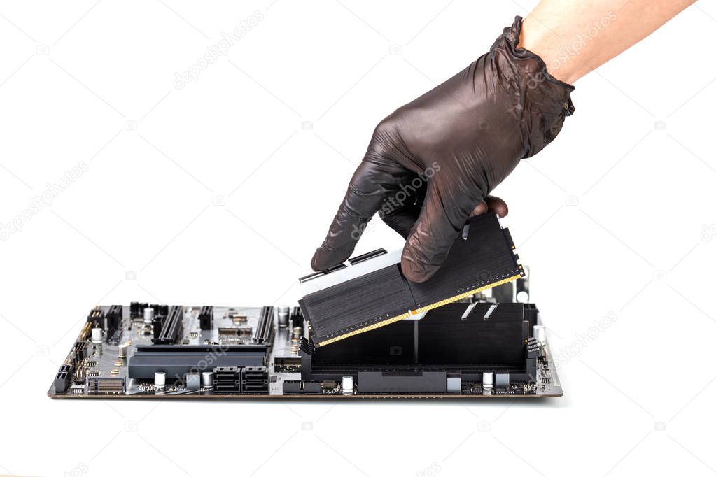 hand in black glove installing memory module with heatsink in pc motherboard isolated on white background