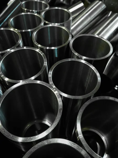 Fundo industrial escuro com tubos de aço brilhantes usinados cnc foco seletivo e tecnologia de desfoque de lente — Fotografia de Stock