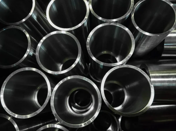 Dark industrial background with cnc machined shiny steel pipes - selective focus and lens blur tech — Stock Photo, Image