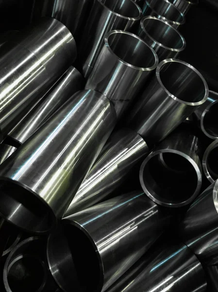 Dark industrial background with cnc machined shiny steel pipes - selective focus and lens blur tech — Stock Photo, Image