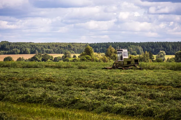 Tula, Rusya - 30 Temmuz 2019: fırtına öncesi yaz tarlasında yeşil saman yapımı traktör - seçici odaklı telefoto çekim — Stok fotoğraf