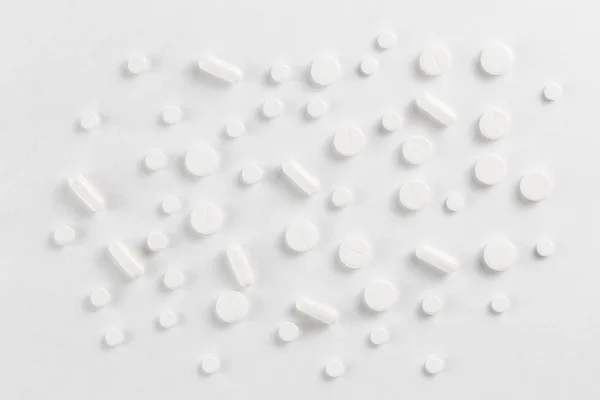 Pills flat background, tablets spreaded on a white - top-down view — Stock Photo, Image