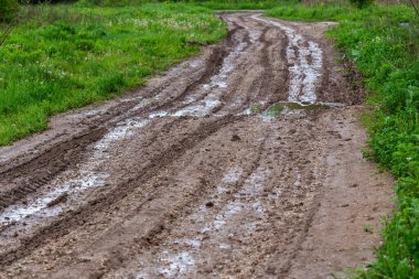 Kirli çamur yolu su birikintileri ve lastik izleri ile - seçici odak ve doğrusal perspektif ile yakın çekim
