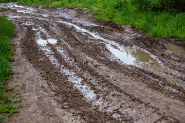 Kirli çamur yolu su birikintileri ve lastik izleri ile - seçici odak ve doğrusal perspektif ile yakın çekim