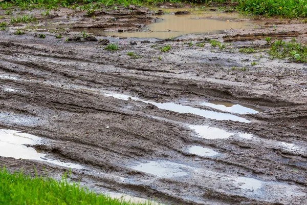 stock image dirty clay mud road with puddles and tire tracks - closeup with selective focus, diagonal composition