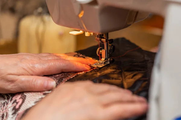Uma visão de close-up do processo de costura, mão de mulher idosa usando máquina de costura, técnica de foco seletivo — Fotografia de Stock