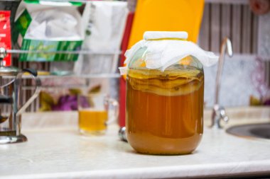 Mutfak masasında cam kavanozda ev yapımı Kombucha çayı.