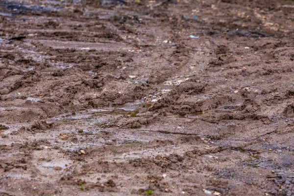 Strada sporca fango argilla con tracce di pneumatici primo piano con messa a fuoco selettiva e sfocatura — Foto Stock