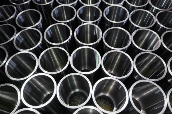 Σκούρο βιομηχανικό υπόβαθρο με cnc επεξεργασμένα στη μηχανή γυαλιστερά σωλήνες χάλυβα - επιλεκτική εστίαση και τεχνολογία θόλωσης φακών — Φωτογραφία Αρχείου