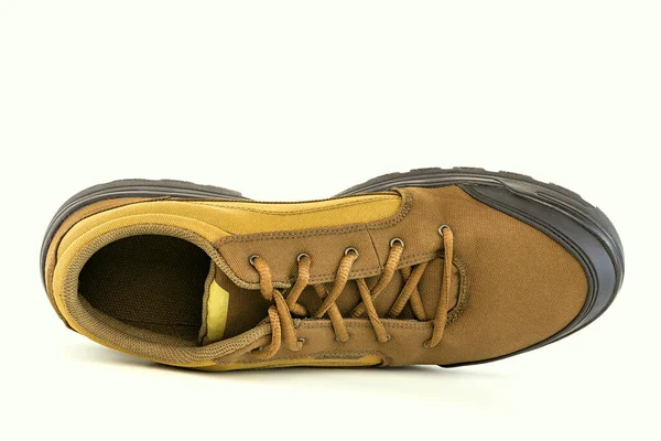 Beyaz arka planda izole edilmiş ucuz sarı kumaş yürüyüş ayakkabısı. — Stok fotoğraf