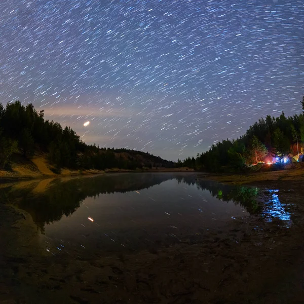 Маленькое озеро под звездами ночью с короткими рельсами и кемпингом летом — стоковое фото
